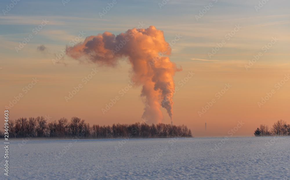 Obraz premium Sonnenaufgang im Winter über einem Kohlekraftwerk 