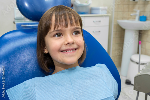 Happy girl in dental chair. Medicine, dentistry and healthcare concept