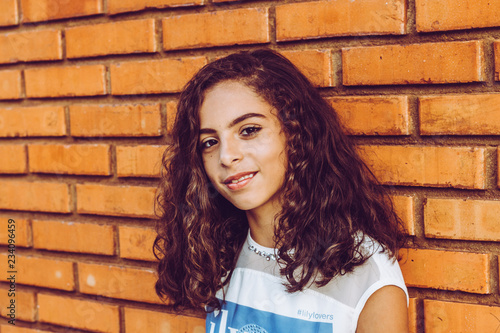 Portrait of beautiful girl smiling on the brick wall
