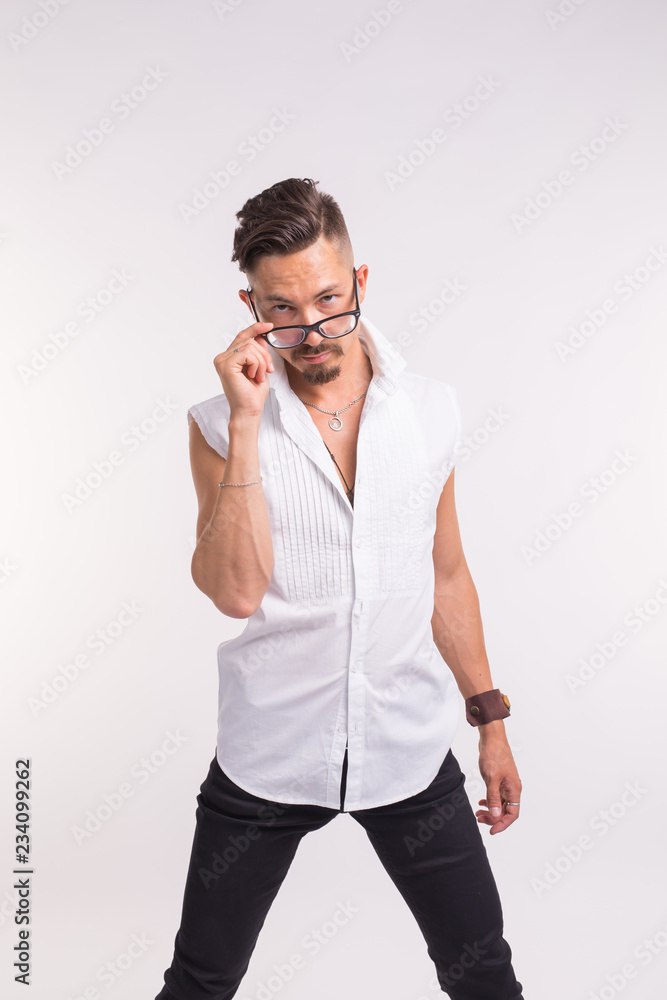 Expression and people concept - young handsome man looking at you through the glasses on white background Expression and people concept - young handsome man looking at you through the glasses on white background