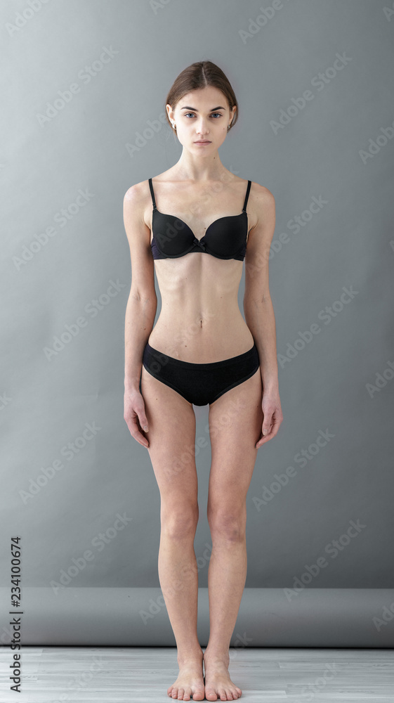 Standard model tests of young pretty woman on a gray background,Test Shots young  models for modeling agency on a gray background with ,young beautiful woman  in underwear. portrait of slim woman Stock