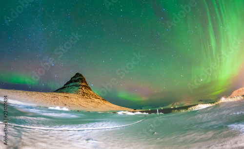 Fototapeta Naklejka Na Ścianę i Meble -  Colorful Aurora Borealis or better known as The Northern Lights and winter milky way over Kirkjufell, Iceland