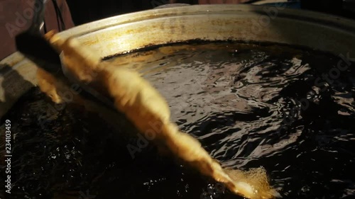 Process of cooking cheburek. Man fry pasties with cheese, meat, onions into large cooking pot cauldron in oil. Fried flatbread piadina naan pita tortilla shelpek cheburek. Caucasian and eastern food. photo