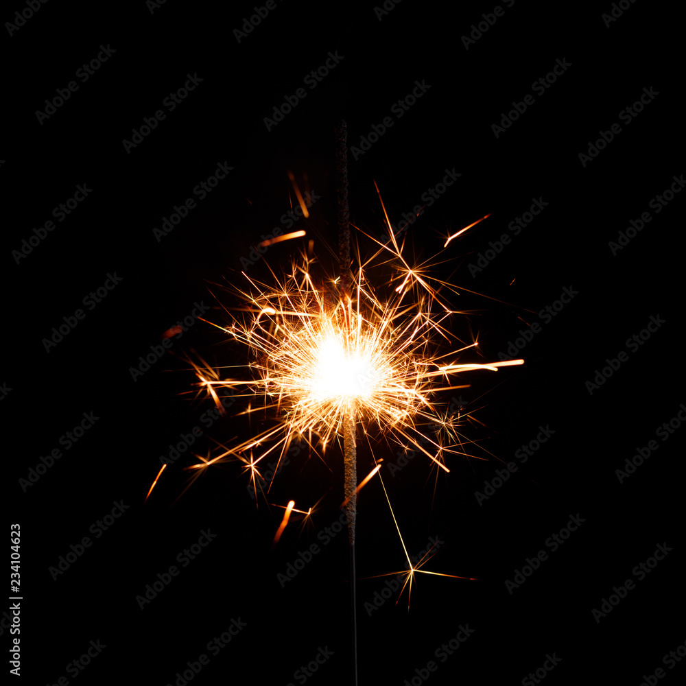 New year sparkler candle isolated on black background. Party backdrop.