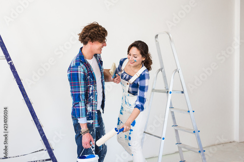 Teamwork and repair concept - young couple doing a renovation in new apartment