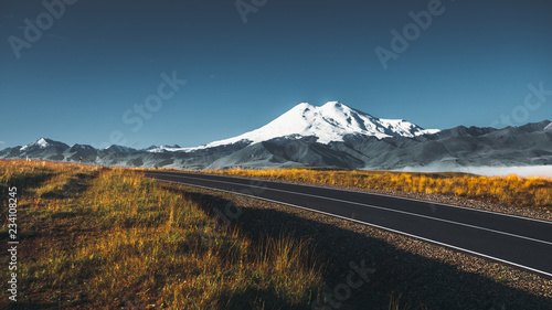 Road to the Elbrus mountain at sunrise, North Caucasus, Russia. The concept of a road trip