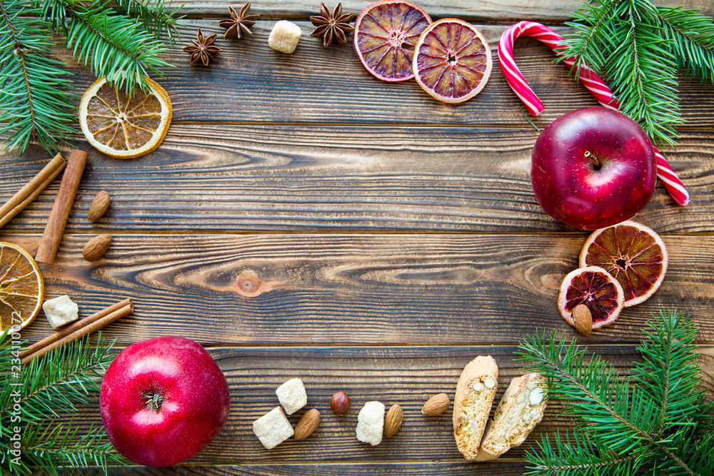 Tasty Christmas background with traditional spices, red apples and candy stick. Space for text.