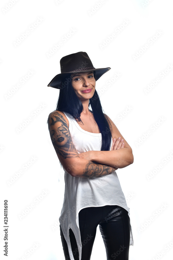 Dark long haired girl wearing a cowboy hat and a sleeveless white shirt posing isolated on white. Dark long haired girl wearing a cowboy hat and a sleeveless white shirt posing isolated on white.