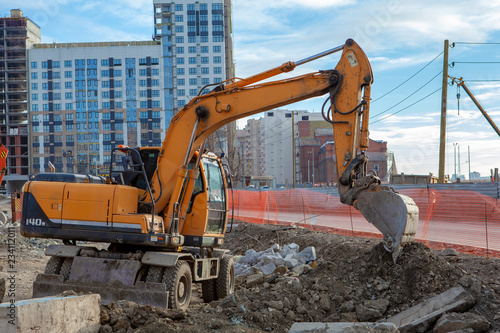 Excavator in the city digging trenches