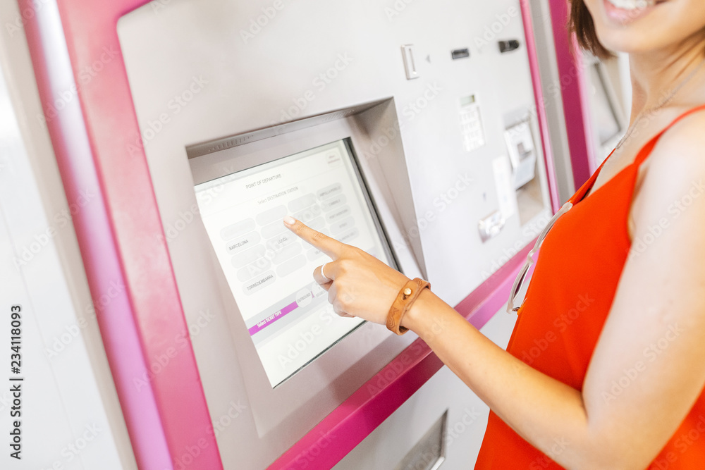Young woman paying at ticket machine in a metro or railroad station Young woman paying at ticket machine in a metro or railroad station