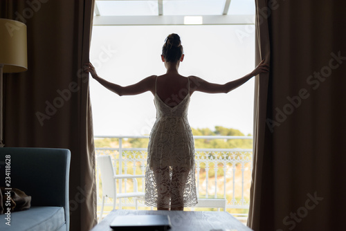 Bild auf Leinwand Slender attractive girl in a white sundress from the back stands at the panorami
