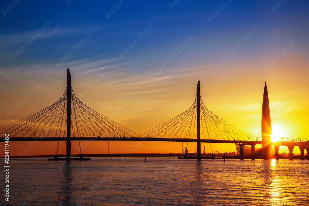 Cable-stayed bridge of Western high-speed diameter through Peter's fairway and the tower of Lakhta center, at sunset, Saint-Petersburg, Russia