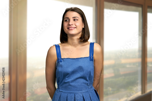 Young joyful woman on window background. Young stylish woman smiling and looking aside. Young pretty female. Free Download Young joyful woman on window background. Young stylish woman smiling and looking aside. Young pretty female. - GFXLoad