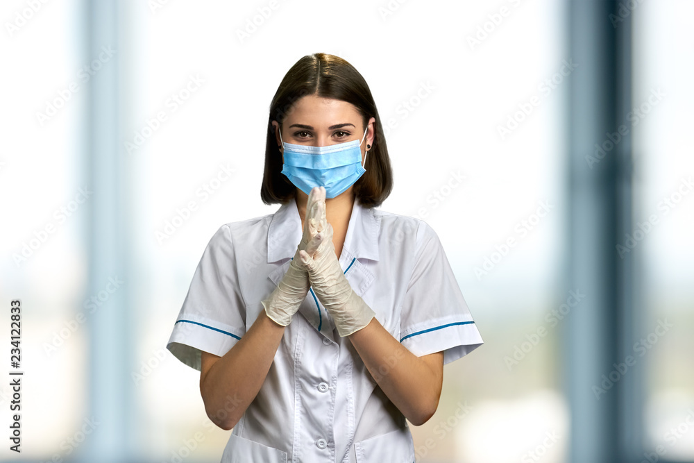 Woman doctor in mask and gloves. Cute young woman doctor in protective medical mask and gloves on hospital background. People, medicine, profession. Woman doctor in mask and gloves. Cute young woman doctor in protective medical mask and gloves on hospital background. People, medicine, profession.