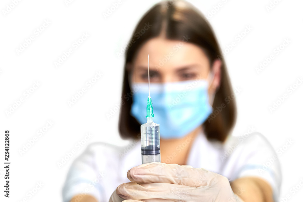 Female doctor in uniform holding syringe. Close up syringe for injection on blurred background. Medicine, vaccine and health care. Female doctor in uniform holding syringe. Close up syringe for injection on blurred background. Medicine, vaccine and health care.