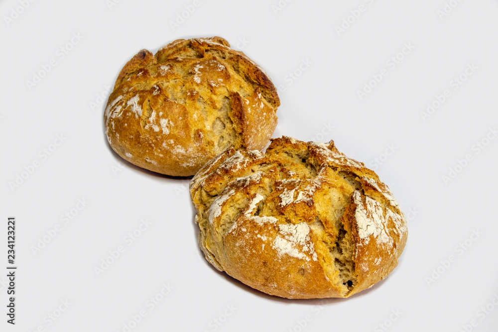 Two rustic bread rolls against white background