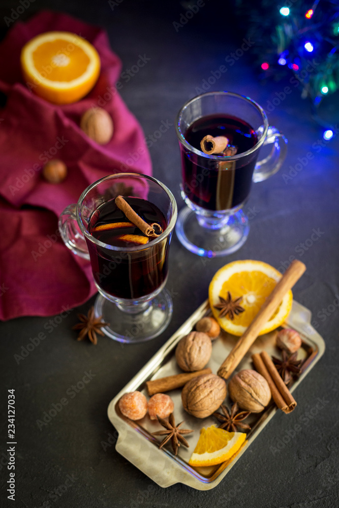 Red mulled wine in glasses with electric lights at dark background Red mulled wine in glasses with electric lights at dark background