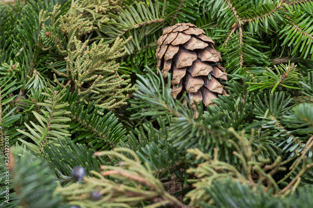 Winter holiday decoration: fraser fir table wreath centerpiece with cones and juniper on burlap background Winter holiday decoration: fraser fir table wreath centerpiece with cones and juniper on burlap background