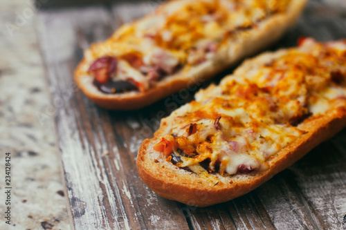French baguette sandwich with assorted filling. Dish on wooden table. Set of bruschetta.