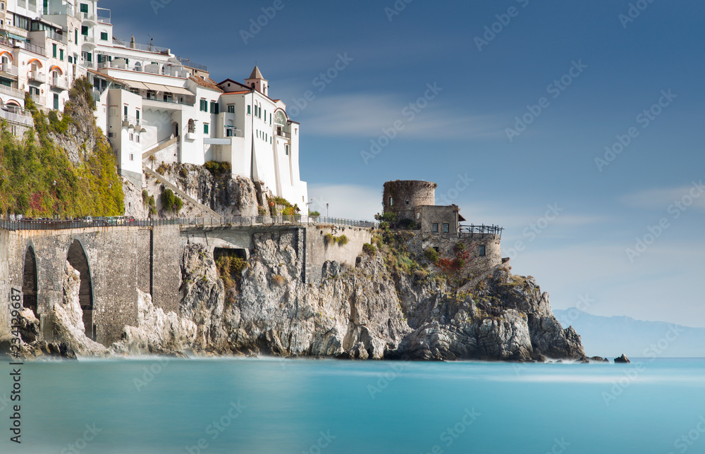 old fortress and buildings on Amalfi coast with blurred sea in long exposure in Italy