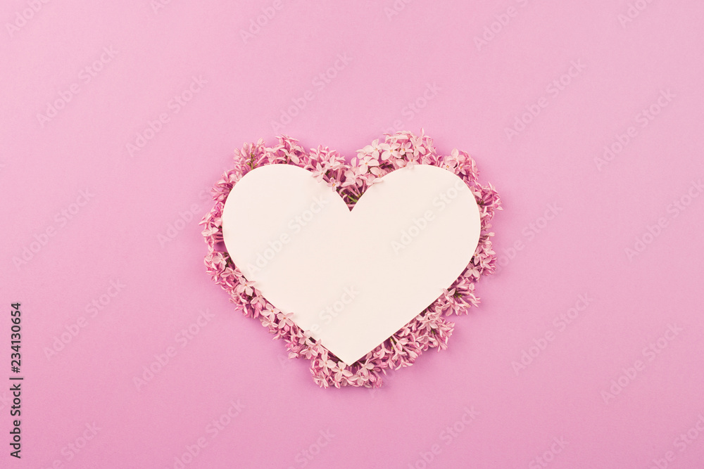 white heart decorated with lilac flowers on pink background. Card for Valentine's day, mother's day, women's day with love