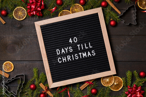 40 Days till  Christmas  countdown letter board on dark rustic wood background with Christmas decoration and fir branch frame top view flatlay photo