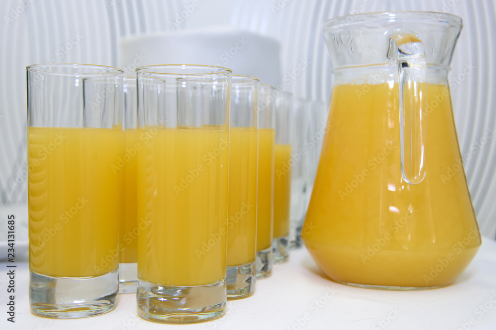 Glasses and a carafe of orange juice. Useful vitamin drink from citrus. Glasses and a carafe of orange juice. Useful vitamin drink from citrus.