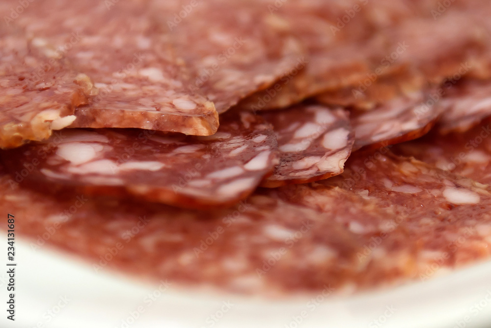 Obraz premium Sausage smoked close. Salami sliced on a plate.