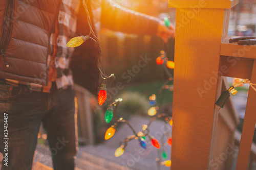 man hanging Christmas lights