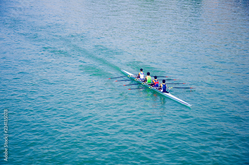 Four sportsmen canoeing, blue river