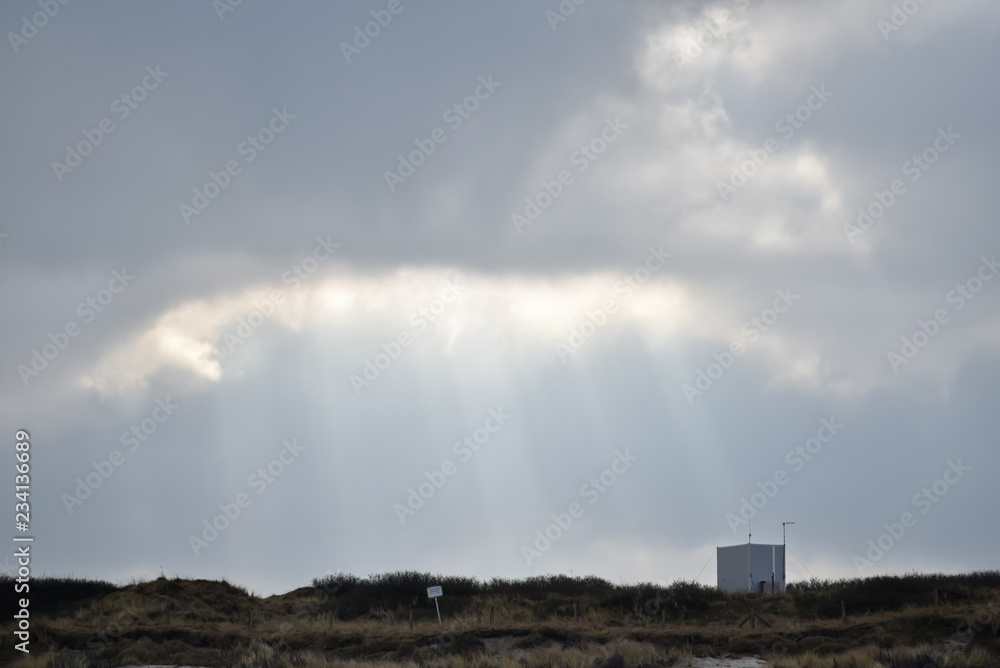 sun light in the clouds over a dune 