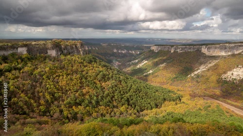 Autumn landscape in mountain valley with fast flying clouds, time-lapse video