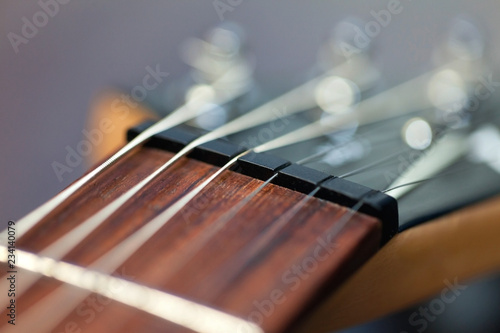 guitar with wooden brown neck and strings, close up blurry background, texture, abstract