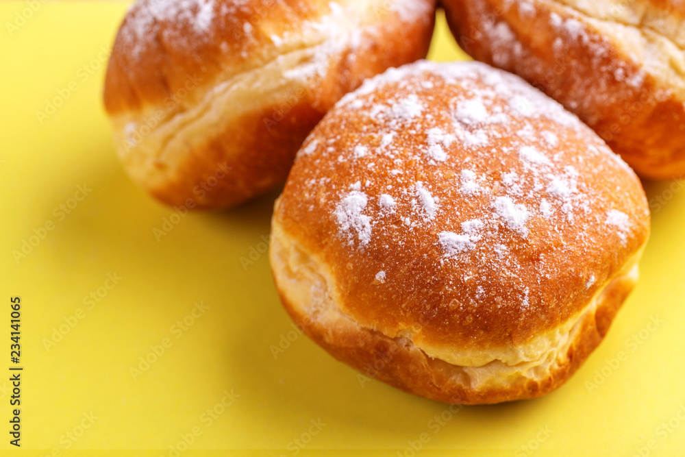 Tasty sweet donuts with powdered sugar on bright yellow background
