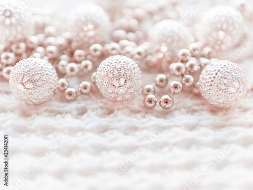 Christmas and New Year decorations on white knitted background. Metal light bulbs with delicate pattern, pale beige beads.
