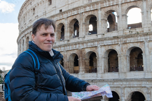 Photography Handsome traveler looking at tourist map in Rome in front of Colosseum