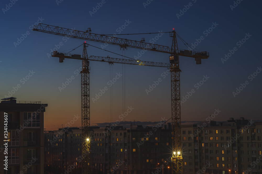 two tower cranes operate late at night