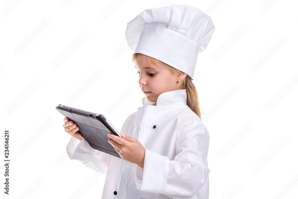 Girl chef white uniform isolated on white background. Holding and looking at the ipad. Landscape image Girl chef white uniform isolated on white background. Holding and looking at the ipad. Landscape image