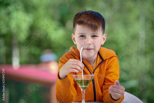 Caucasian boy drinking nonalcoholic mojito on the nature.
