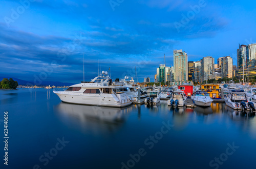 Sunset at Coal Harbour in Vancouver British Columbia with downtown buildings boats and reflections in the water © SvetlanaSF