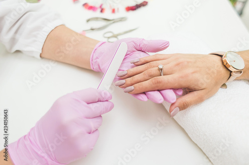 Young woman getting manicure in beauty salon. Close-up