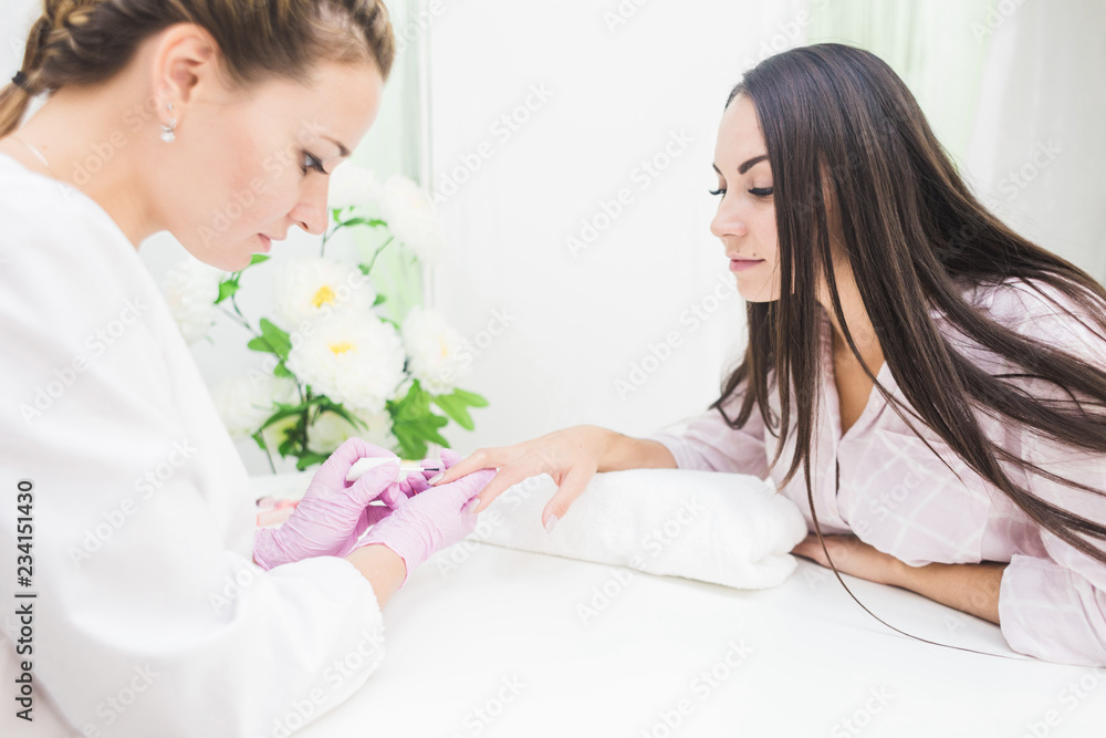 Young woman getting manicure in beauty salon Young woman getting manicure in beauty salon