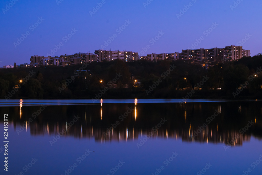 Obraz premium Broad plan on building in city over the water at the sunset