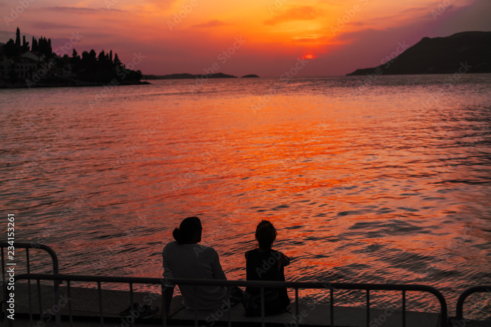 Young couple sitting on the beach near the sea