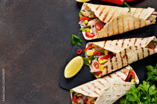 Taco - traditional dish of Mexican cuisine. Mexican tacos with beef, vegetables and sauce. Top view.