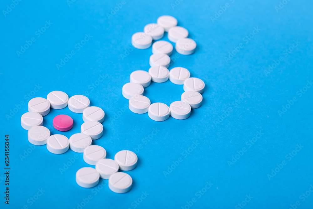 gender symbols from pills on a blue background with copy space for text on a medical topic.