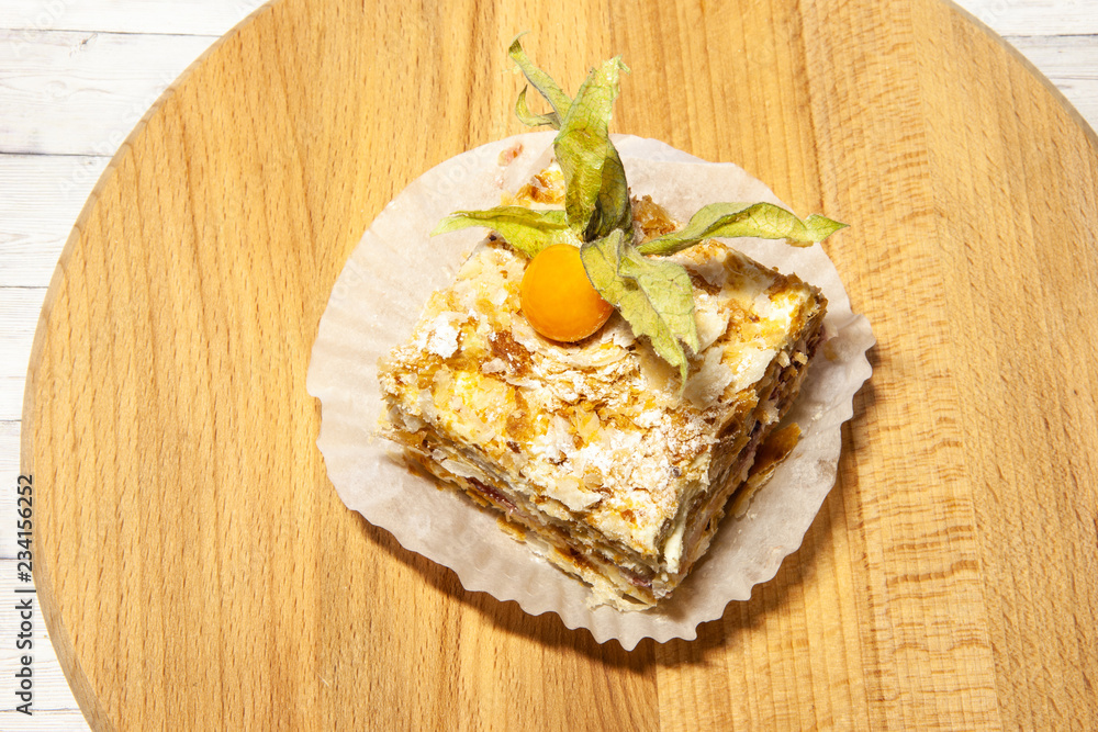 Layered cake with cream Napoleon vanilla slice on wooden background, top view Layered cake with cream Napoleon vanilla slice on wooden background, top view