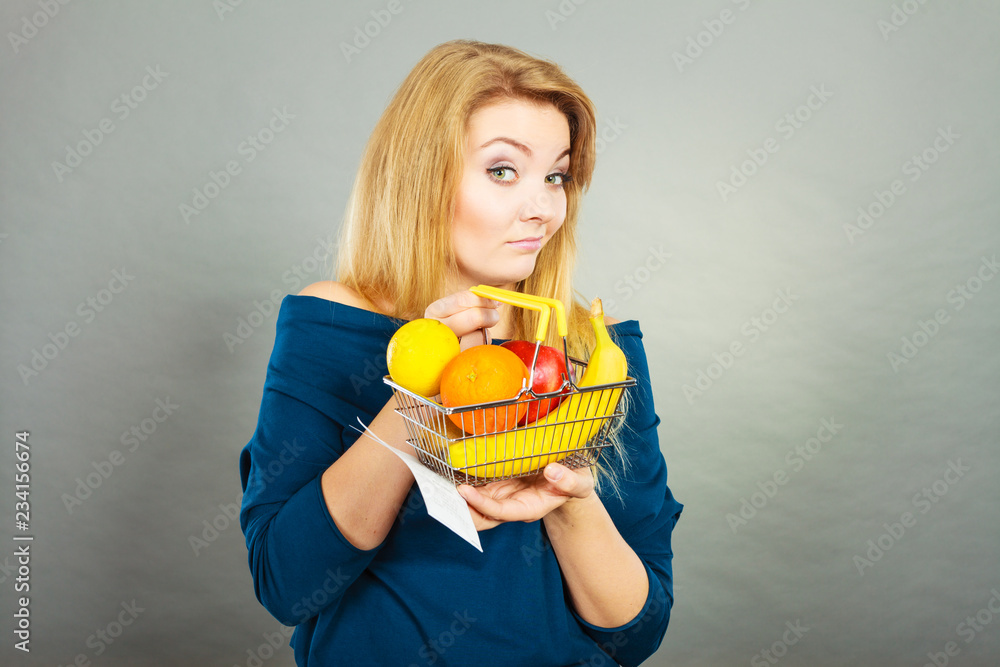 Woman holding shopping basket with fruits inside Woman holding shopping basket with fruits inside