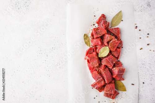 Sliced raw beef with spices on a white background, top view. photo