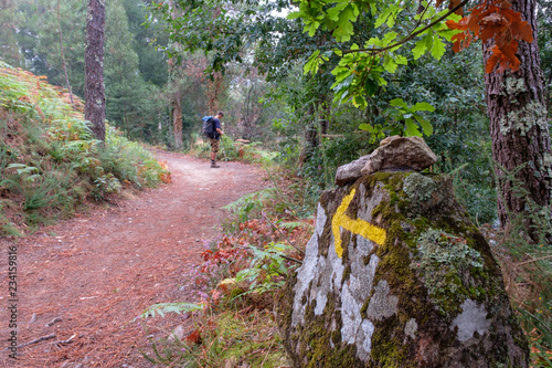 Gelber Pfeil und Pilger auf dem Jakobsweg (von Porto nach Santiago de Compostela)